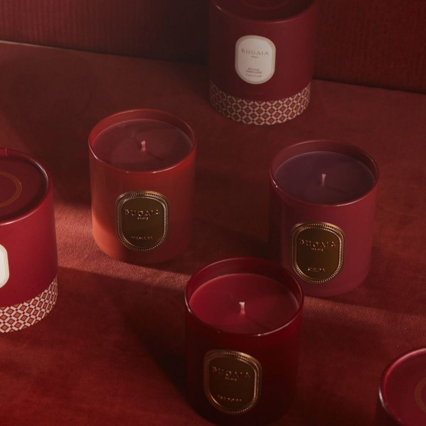 BUGAIA Paris Duftkerzen in burgunderfarbenen Gläsern mit goldenen Etiketten – luxuriöse aromatische Designerkerzen in warmen Rottönen.