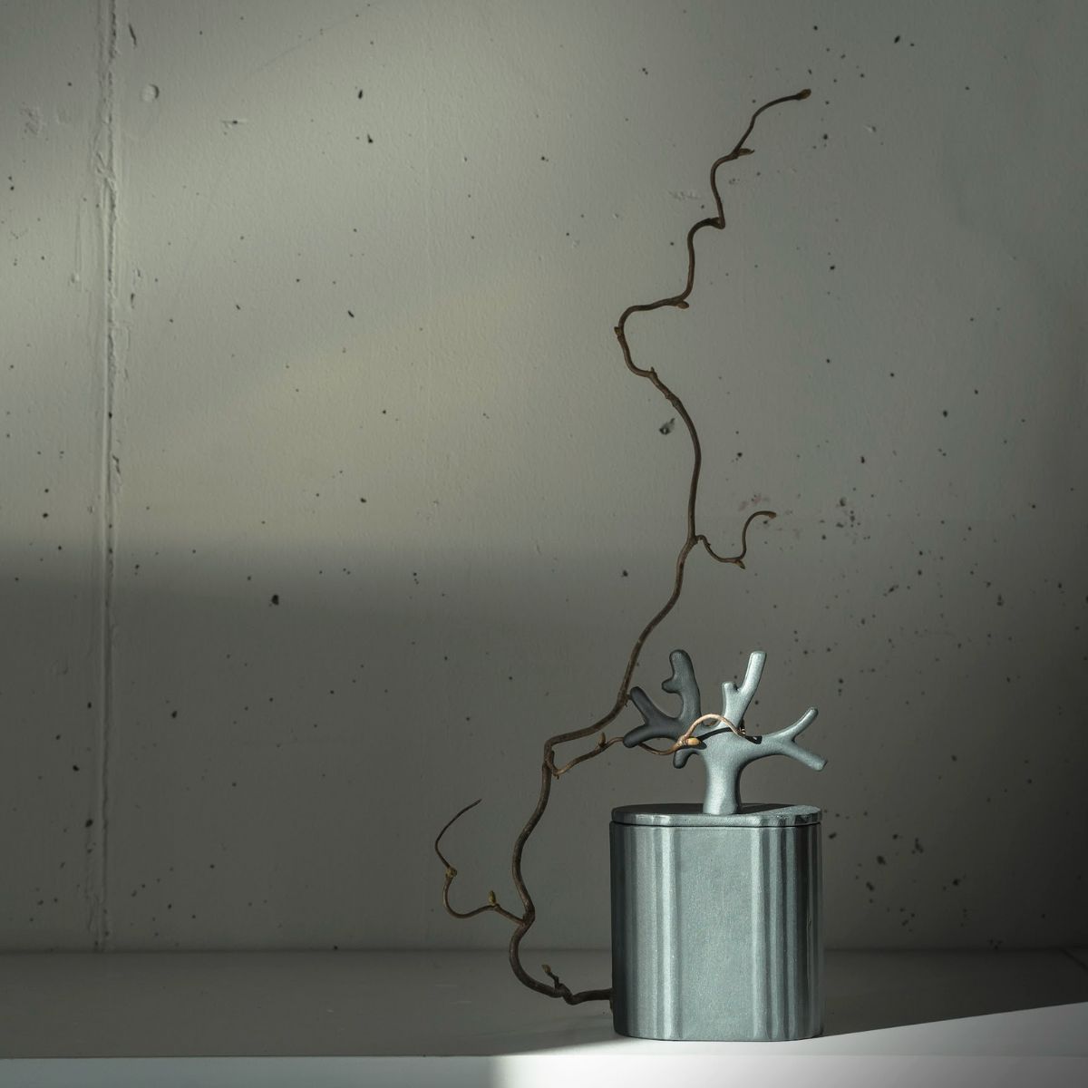 Objet design Kyuka – objet décoratif minimaliste gris avec un élément sculptural de branche dans le style japonais moderne
