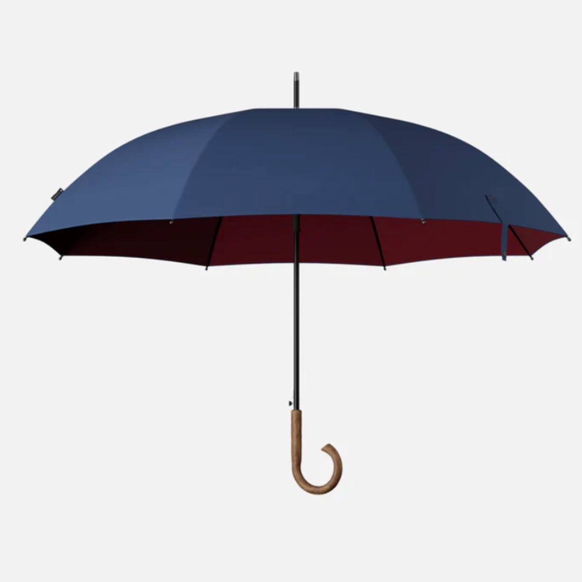 Blauer Sapor Design Stockschirm mit burgunderroter Innenseite und gebogenem Holzgriff vor hellem Hintergrund.